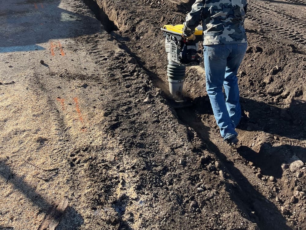 Compacting a sand-bedded sewer trench to reopen the alley the same day
